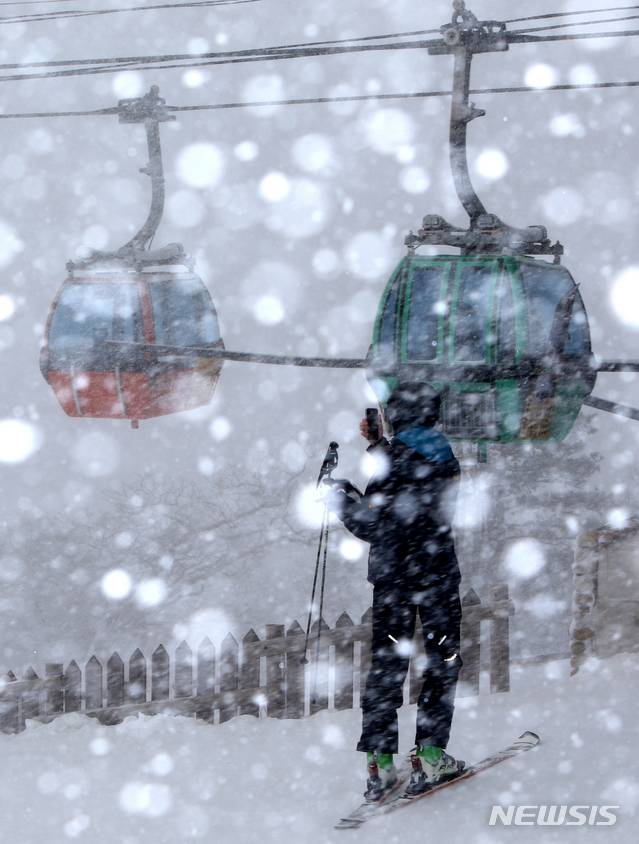 [평창=뉴시스] 김경목 기자 = 스키어가 18일 오후 대설주의보가 발효 중인 강원도 평창 발왕산용평리조트 드래곤캐슬에서 아름다운 겨울 풍경을 스마트폰에 간직하고있다. 2021.01.18. photo31@newsis.com