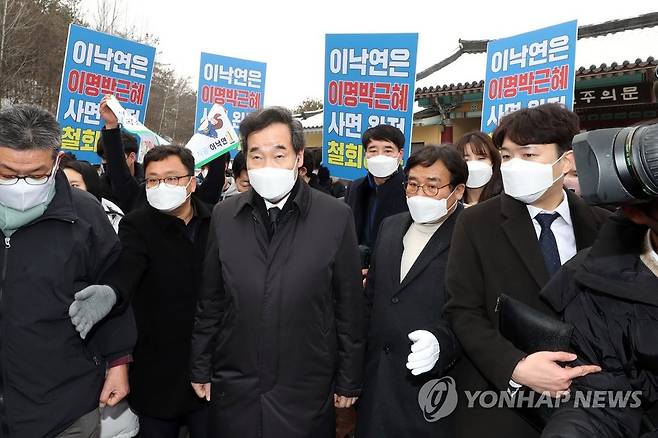 광주 찾은 이낙연 (광주=연합뉴스) 정회성 기자 = 더불어민주당 이낙연 대표가 18일 오후 광주 북구 운정동 국립 5·18민주묘지 참배를 마친 뒤 다음 일정을 위해 이동하고 있다. 이 대표 주변에서 '사면론'에 반대하는 광주시민이 팻말을 들고 있다. 2021.1.18 hs@yna.co.kr