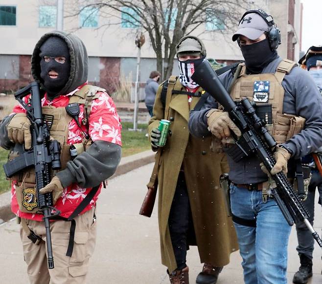 총들고 행진하는 트럼프 지지자들 - 미국 미시간주 랜싱시의 주(州) 의사당 앞에서 17일(현지 시각) 친트럼프 성향 무장 단체가 소총을 들고 집회를 벌이고 있다. 미 연방수사국(FBI)은 취임식이 열리는 20일을 전후해 무장 시위가 일어날 수 있다고 경고했다. /로이터 연합뉴스