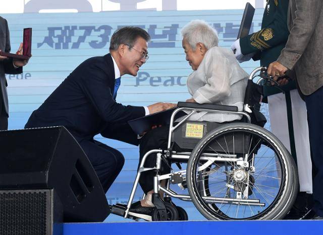 문재인 대통령이 2018년 8월 15일 서울 용산구 국립중앙박물관 열린마당에서 열린 제73주년 광복절 및 정부수립 70주년 경축식에서 고 손용우 선생에게 건국훈장 애족장을 추서해 배우자 김경희에게 친수 하고 있다. 고영권 기자