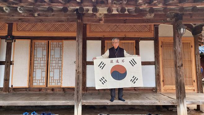 불원복기(不遠復旗)를 들어 보이는 장흥고씨 학봉종가 종손 고영준씨. 바른길로 되돌아와 후회를 남기지 않으리라는 주역복괘 ‘불원복’, 고광순은 나라를 곧 되찾게 될 것이니 힘것 싸우라는 격려를 담은 군기를 만들고 조석으로 배례했다. [남도일보 제공]