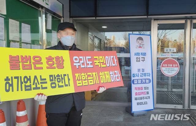 [천안=뉴시스]이종익 기자 = 충남 천안지역의 야간업소 운영자라고 밝힌 남성이 19일 오전 천안시청사 앞에서 문을 잠그고 단속을 피해 불법으로 운영되는 유흥업소 단속 등을 요구하며 집합금지 해제를 촉구하는 시위를 하고 있다. 2021.01.19. 007news@newsis.com