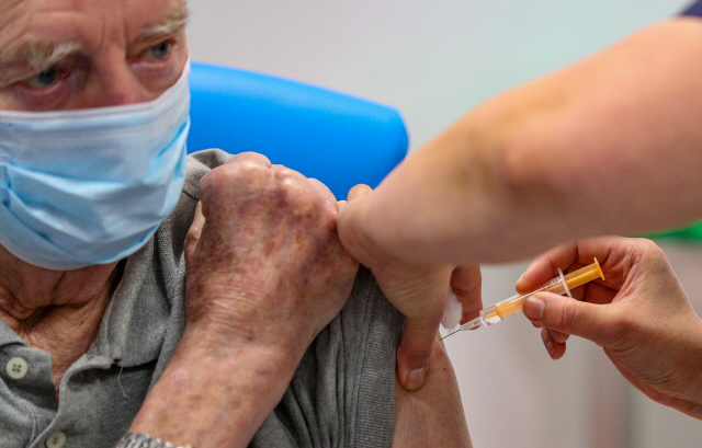 18일(현지 시간) 영국 블랙번에서 한 노인이 코로나19 백신을 맞고 있다./로이터연합뉴스