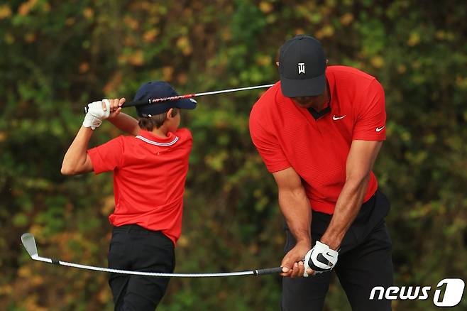 타이거 우즈가 지난해 12월 20일(현지시간) 플로리다주 올랜도의 리츠 칼턴 골프클럽에서 열린 PNC 챔피언십 마지막 날 경기에 앞서 아들 찰리와 함께 스윙 연습을 하고 있다. © AFP=뉴스1