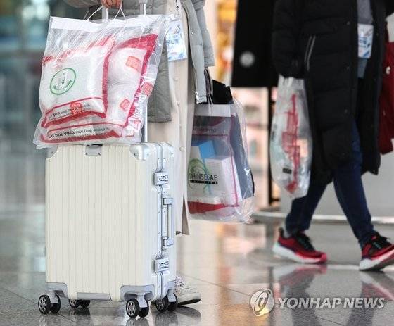 인천국제공항에서 제주항공 무착륙 관광비행에서 면세품을 구입해 들어오는 관광객들