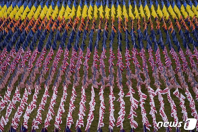 조 바이든 미국 대통령 취임식이 20일(현지시간) 열린 가운데, 네셔널 몰이 국기로 가득 차 있다.  이 깃발들은 코로나19 사태로 식장에 함께 못한 일반 미국민들을 대변한다.© 로이터=뉴스1 © News1 박재우 기자