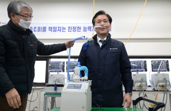 성윤모 산업통상자원부 장관(오른쪽)이 21일 경기 파주시에 있는 인공호흡기 제조업체 멕아이씨를 방문해 인공호흡기 제품을 직접 체험하고 있다. 산업부 제공