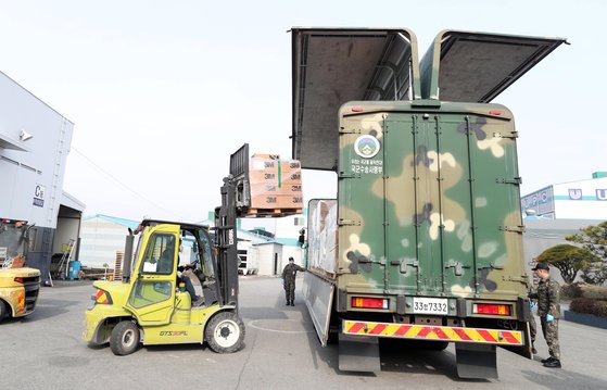 지난해 3월 9일 국군수송사령부 소속 전담수송팀이 충남 논산시 UPC논산물류창고에서 대구·경북지역에 지원할 정부지원 의료물자 마스크 등을 차량에 옮기고 있다. [뉴스1]