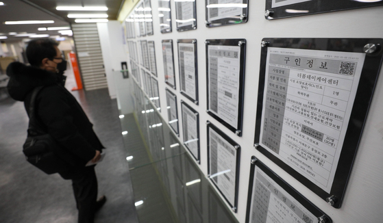 A man looks at a job bulletin board at an employment and welfare center in Mapo District, western Seoul, on Jan. 13. [NEWS1]
