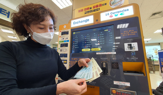 An Emart employee shows off Shinsegae Department Store gift certificates issued in exchange for foreign currency at Emart’s Seongsu branch in eastern Seoul on Thursday. Emart installed kiosks capable of exchanging paper money from 16 countries and coins from 11 countries into Shinsegae gift certificates at six of its branches including the Seongsu branch and Yongsan branch in central Seoul. [YONHAP]