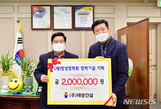 [장성=뉴시스]=㈜태영건설 문병태 대표가 (재)장성장학회 이사장인 유두석 장성군수(왼쪽)에게 장학금 200만원을 기탁한 후 기념촬영을 하고 있다. (사진=장성군 제공) 2021.01.21. photo@newsis.com