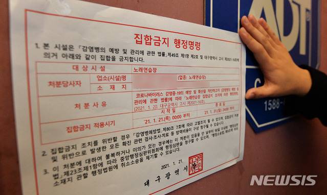 [대구=뉴시스] 이무열 기자 = 대구 노래연습장 도우미 관련 신종 코로나바이러스 감염증(코로나19) 확산 방지를 위해 21일 오후 중구보건소 위생과 관계자들이 노래연습장 입구에 집합금지 행정명령 안내문을 붙이고 있다. 2021.01.21. lmy@newsis.com