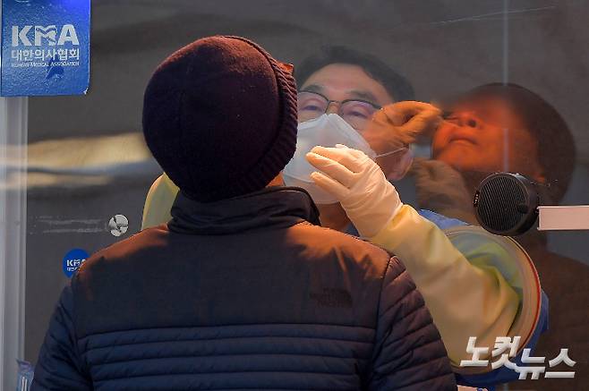 국내에서 신종 코로나바이러스 감염증(코로나19) 확진 환자가 처음 발생한 지 1년째가 되는 20일 서울광장 임시선별검사소에서 의료진이 검체를 체취하고 있다. 이날 신규 확진자는 404명으로 집계됐다. 박종민 기자