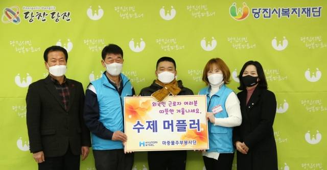 현대제철 당진제철소 마중물 주부봉사단이 22일 외국인 근로자 200명에게 수제 목도리를 전달하고 기념촬영을 하고 있다.[사진 = 현대제철]