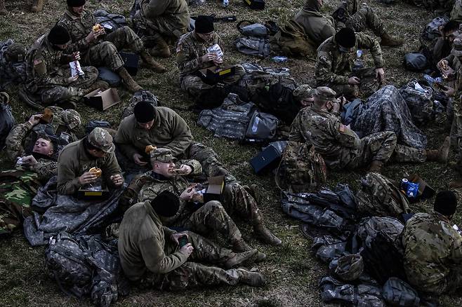 미국 아이다호 주 방위군이 21일 아침 워싱턴 DC 연방의사당 동편 잔디밭에서 취침후 기상해 간편식으로 아침 식사를 하고 있다. EPA=연합뉴스