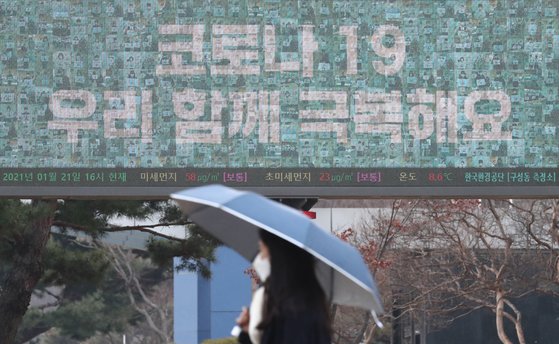 전국적으로 흐리고 비가내린 21일 오후 대전 유성구 한국과학기술원(KAIST) 캠퍼스에서 우산을 쓰고 지나는 학생 뒤로 보이는 전광판에 '코로나19 우리 함께 극복해요' 문구가 적혀 있다. *사진 속 인물과 기사내용은 관련 없습니다. 뉴스1