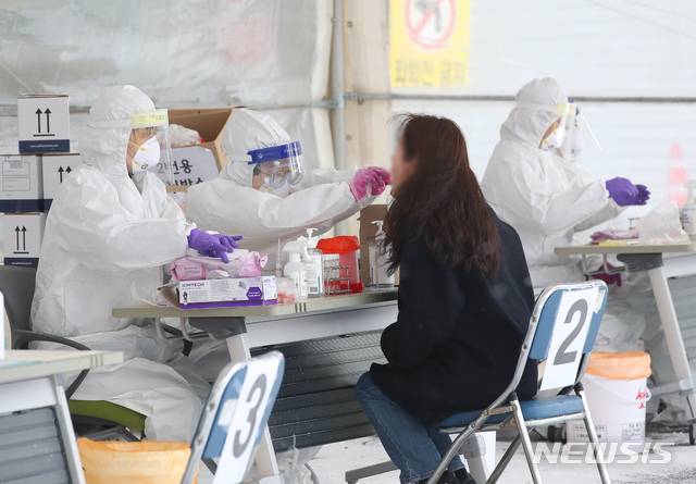 [제주=뉴시스]우장호 기자 = 제주 지역에 강추위 기승을 부리고 있는 7일 제주시보건소 내 주차장 한 켠에 마련된 코로나19 선별진료소에서 의료진들이 검체 채취를 하고 있다. 2021.01.07. woo1223@newsis.com