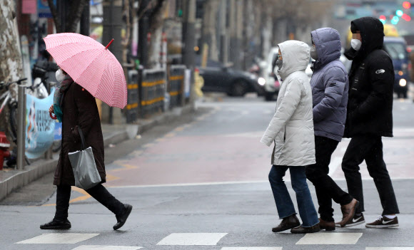 겨울비 피하기 - 겨울비가 내린 21일 서울 시내에서 한 시민이 우산을 쓰고 있다. 우산이 없는 사람들은 모자를 썼다. 2021.1.21 연합뉴스