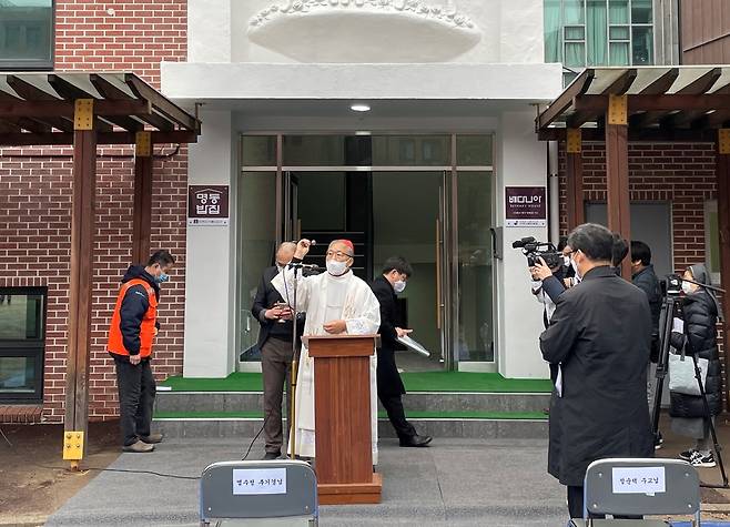 "'명동밥집'에 축복을" (서울=연합뉴스) 천주교 서울대교구가 운영하는 무료급식소 '명동밥집'이 22일 정식으로 문을 열었다. 서울대교구는 이날 서울 중구 옛 계성여중고 식당 자리인 샛별관 앞에서 명동밥집과 이주·난민 쉼터 '베다니아의 집' 축복식 및 현판식을 개최했다. 서울대교구장 염수정 추기경(가운데)이 축복하고 있다. 2021.1.22 [서울대교구 제공. 재배포 및 DB금지] (끝)