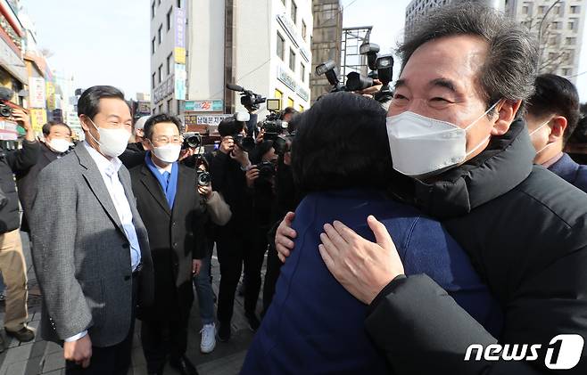 코로나19 민생현장을 찾은 이낙연 더불어민주당 대표가 23일 서울 중구 남대문시장 입구에서 서울시장 보궐선거 경선에 나선 박영선 전 중소벤처기업부 장관과 포옹하고 있다. 왼쪽은 보궐선거에 출마한 우상호 의원. 2021.1.23/뉴스1 © News1 이동해 기자