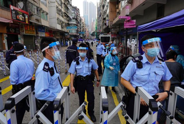 홍콩 도심인 야우마테이 지역이 23일 새벽 코로나19 확산억제 대책의 일환으로 전격 봉쇄된 가운데 경찰관들이 도로 통제에 나서고 있다. 홍 홍콩 AP=연합뉴스