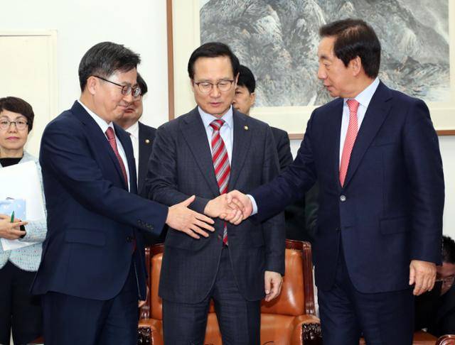 2018년 12월 6일 김동연(앞줄 왼쪽부터) 경제부총리 겸 기획재정부 장관, 더불어민주당 홍영표, 자유한국당 김성태 원내대표가 국회에서 2019년도 예산안 합의 결과를 발표하고 기념사진을 촬영하기 위해 손을 잡고 있다. 연합뉴스