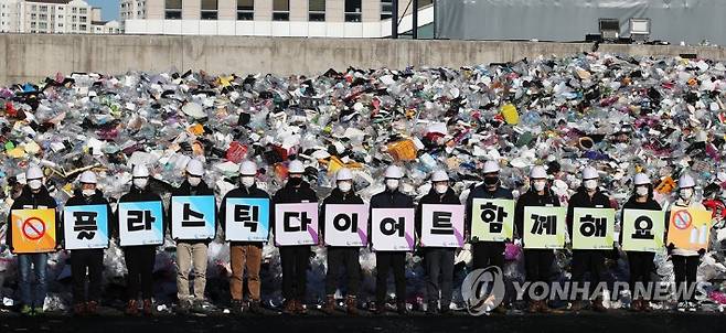 (수원=연합뉴스) 홍기원 기자 = 19일 오전 경기도 수원시 영통구 수원시자원순환센터에서 수원도시공사 임직원들이 '플라스틱 다이어트 함께해요' 문구가 새겨진 피켓을 들고 탈 플라스틱 캠페인을 하고 있다. 2021.1.19 xanadu@yna.co.kr