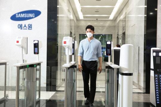 한 고객이 에스원의 워크스루형 얼굴인식 스피드게이트를 통과하고 있다. 에스원 제공