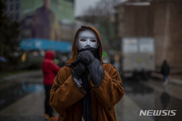 스페인 수도 마드리드에서 23일(현지시간) 가면을 쓴 한 남성이 신종 코로나바이러스 감염증(코로나19)에 따른 규제에 반대하는 시위에 참가하고 있다. 신종 코로나바이러스 감염증(코로나19) 백신 접종과 관련한 국가 규정을 어기고 백신을 새치기 접종한 스페인군 참모총장과 고위 장성들이 강제 전역당했다. 2021.1.24./사진=[마드리드(스페인)=AP/뉴시스]