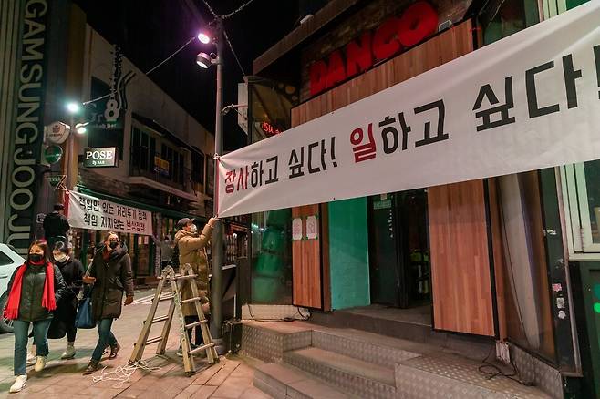 서울 용산구 이태원 상인들이 이태원 중심 상가 거리인 세계음식문화거리에 코로나19 방역 지침의 합리적인 조정과 배상을 요청하는 펼침막을 내걸고 있다.