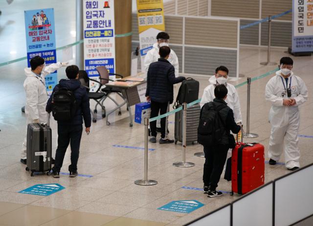 20일 인천국제공항 제1여객터미널에서 해외 입국자들이 방역 관계자들로부터 안내를 받고 있다. 인천공항=뉴스1