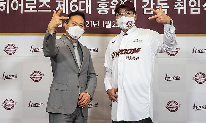 홍원기 키움 히어로즈 신임 감독(오른쪽)이 25일 고척 스카이돔에서 열린 취임식에서 허홍 대표이사와 함께 손가락으로 팀을 상징하는 ‘K마크’를 표시하고 있다. 키움 히어로즈 제공