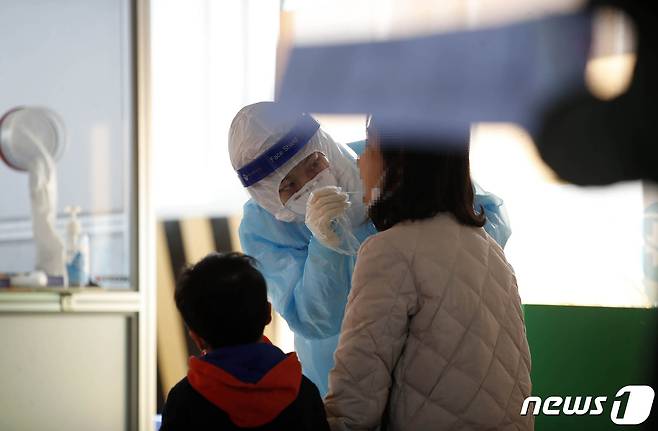 지난 24일 오후 광주 북구선별진료소에서 엄마와 자녀가 함께 코로나19 검사를 받고 있다.(광주북구 제공)2021.1.24/뉴스1 © News1 허단비 기자
