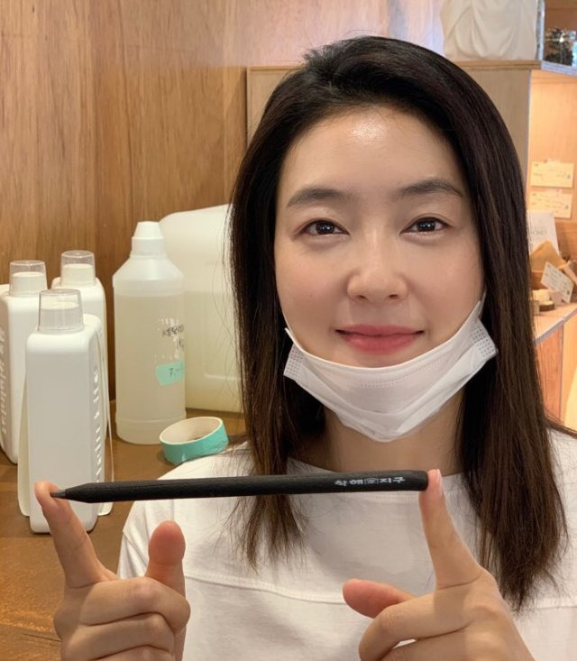 배우 박진희 씨가 제로 웨이스트 가게(쓰레기 없는 가게)인 서울 마포구 ‘알맹’을 찾아 커피가루로 만든 연필을 들어 보이고 있다. 박진희 씨 제공