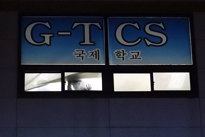 26일 오후 광주 광산구 티시에스(TCS)국제학교에서 한 합숙생이 창밖을 내다보고 있다. 방역당국은 학생 122명이 합숙한 이곳에서 이날 학생과 교직원, 교인 등 100명이 코로나19에 확진됐다고 밝혔다. 연합뉴스