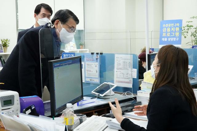 은성수 금융위원장이 20일 소상공인 2차 금융지원 프로그램을 점검하기 위해 서울 기업은행 공덕동 지점을 방문해 설명을 듣고 있다. 금융위원회 제공