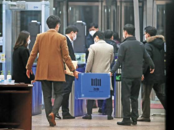 불법 출국금지 사건을 수사중인 수원지검이 지난 21일 법무부 출입국·외국인정책본부에서 압수한 물품 상자를 들고 철수하고 있다. [뉴스1]
