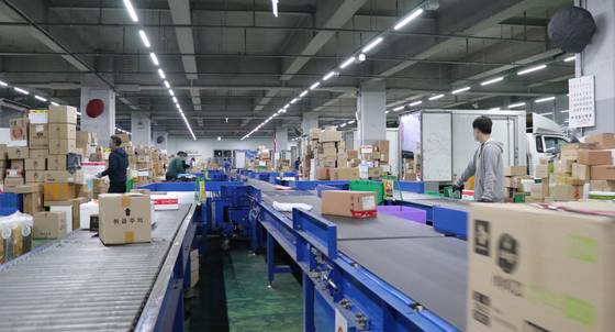 Employees sort parcels for delivery at a CJ Logistics warehouse in Geumcheon District, southern Seoul, on Tuesday. The logistics company in October said it will be hiring 4,000 people by March whose jobs will be exclusively sorting parcels to ease the burden on deliverymen. As delivery goods purchased online spiked due to Covid-19, last year 16 died possibly from overwork. [CJ LOGISTICS]