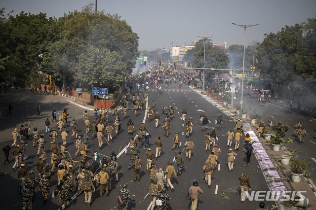 [뉴델리=AP/뉴시스] 인도 경찰들이 26일 합의 시위 루트를 버리고 바리케이틀 부수며 수도 시내로 진출하는 농부들을 추격 해산하고 있다