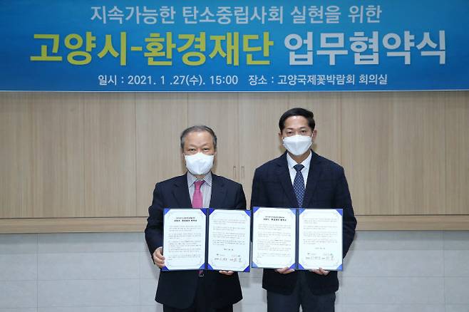 이재준 시장(오른쪽)과 최열 이사장이 협약서를 들어보이고 있다.(사진=고양시 제공)