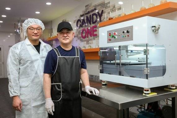 한국생산기술연구원 제주본부 청정웰빙연구그룹 고정범(왼쪽) 박사와 캔디원 강민식 대표가 젤리 자동 커팅 모듈 앞에서 서 있다. 생산기술연구원 제공