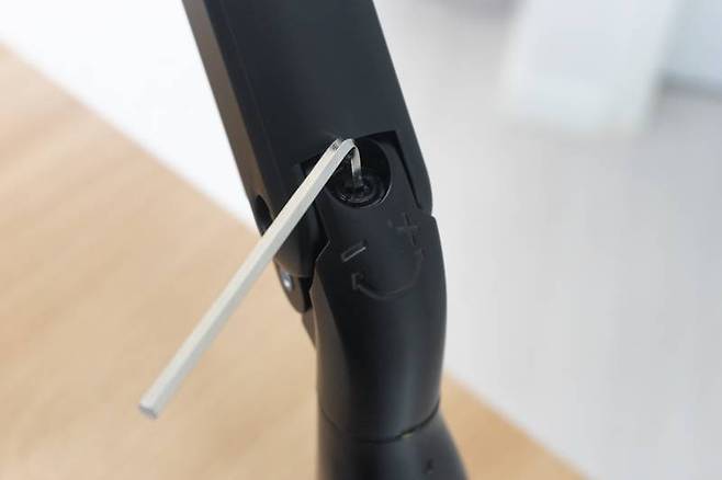 모니터 암 축을 보면 -/+로 표기된 육각 나사가 있는데, 이 나사가 장력 조절 장치다. 출처=IT동아