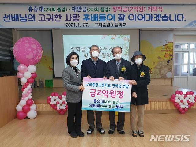 [제주=뉴시스] 제주 구좌중앙초등학교에 장학금 2억원을 전달하고, 기념 촬영하고 있는 홍승대·채만금 부부. (사진=구좌중앙초 제공)