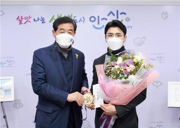 윤화섭 안산시장은 28일 시청 집무실에서 ‘2021 도하 월드 마스터스 유도대회’에서 우승을 차지한 시청 유도부 소속 김원진 선수에게 우승을 축하하는 꽃다발과 포상금을 건넸다. / 사진제공=안산시