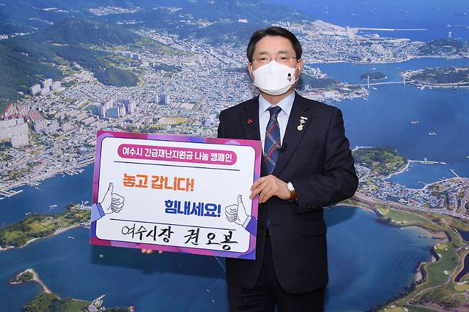 권오봉 여수시장이 "놓고 갑시다. 힘내세요"라는 문구가 적힌 피켓을 들고 재난지원금 나눔 캠페인을 하고 있다. 여수시 제공