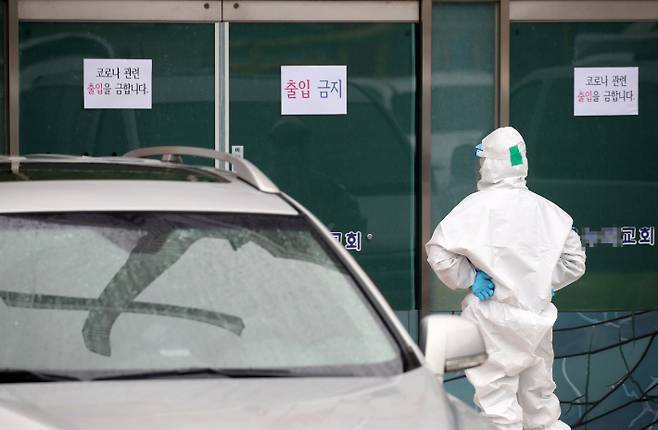 지난 16일 대전 IM선교회가 운영하는 IEM국제학교 구성원 40명이 방문한 강원 홍천군의 한 교회에서 보건소 관계자가 코로나19 확진자 이송을 위해 기다리고 있다. 연합뉴스