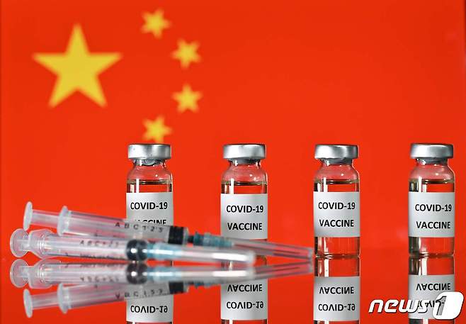 중국 오성홍기 앞에 놓인 코로나19 백신 모형. © AFP=뉴스1