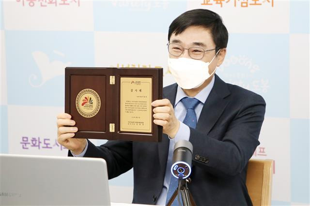 지난 27일 ‘지속가능발전 지방정부협의회 온라인 영상회의에 참여한 이동진 서울 도봉구청장이 이날 받은 감사패를 들어 보이고 있다.도봉구 제공