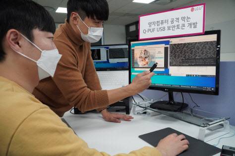 LG유플러스 직원들이 양자내성암호 기술이 적용된 Q-PUF USB를 들어보이고 있다.(사진=LG유플러스 제공)