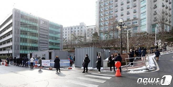 (서울=뉴스1) 이승배 기자 = 30일 오전 서울 성동구 한양대병원에서 직원과 의료진, 시민들이 신종 코로나바이러스 감염증(코로나19) 검사를 받기 위해 줄 서 있다.  전날 코로나19 확진자가 나온 한양대병원에서는 병원 입원 환자의 가족이 27일 최초 확진된 후 병원 환자, 가족, 간병인 등 26명이 추가 감염돼 관련 확진자는 총 27명(서울 22명)으로 늘어났다. 2021.1.30/뉴스1